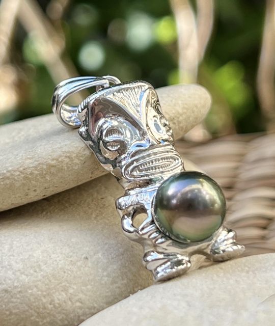 Aus rhodiniertem 925er Silber gefertigt, beherbergt dieser Tiki-Anhänger eine Tahiti-Perle im Tropfenschliff Peacock von 9,95 mm, Qualität AA+, mit lebendigem Glanz und wechselnden Schattierungen - zertifiziert und garantiert.