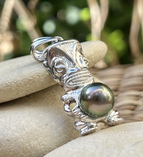En argent 925 rhodié, ce pendentif Tiki accueille une perle de Tahiti drop peacock de 9,95 mm, qualité AA+, au lustre vibrant et aux reflets changeants - certifié et garanti