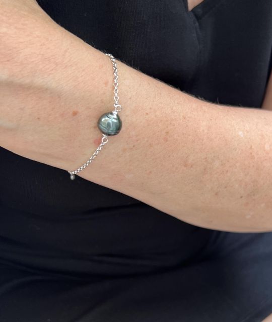 Gena — Geflochtenes Armband mit einer intensiv grün umrandeten Tahiti-Perle (10,45 mm) im Zentrum.