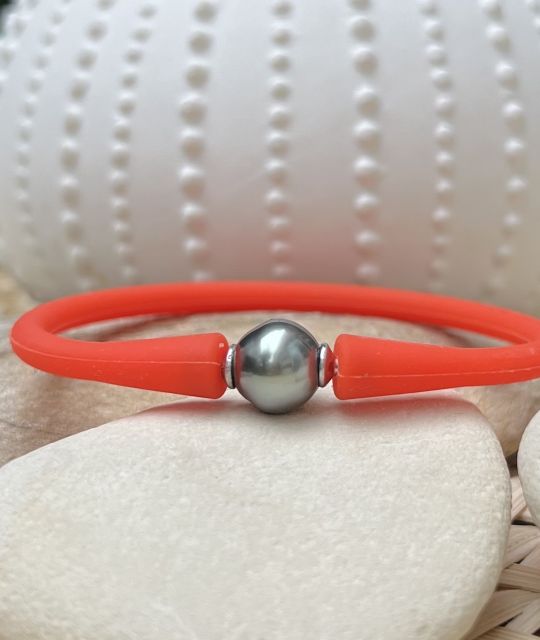 Découvrez notre bracelet en silicone orange ajustable orné d’une perle de Tahiti aux nuances intriguantes de gris et de bleu !