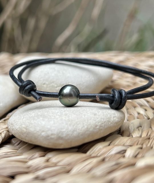 Schwarzes Lederarmband mit verstellbaren Knoten, verziert mit einer runden Tahiti-Zuchtperle (8,88 mm, Qualität A+) in der Farbe Pfau mit sehr hohem Glanz.