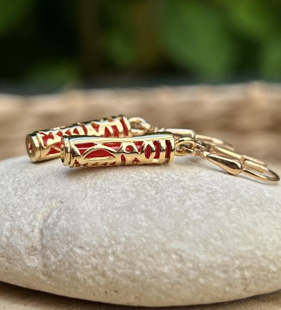 Boucles d’oreilles Tiki plaqué or et résine corail, symbole d’harmonie. Légères, lumineuses, inspiration polynésienne.
