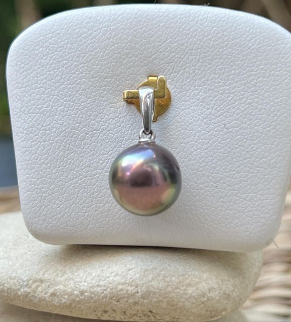 Colgante en plata 925 rodiada adornado con una perla de Tahití redonda de 10,18 mm, calidad AA+, en un color raro que mezcla rosa, verde y violeta, y con un lustre excelente.