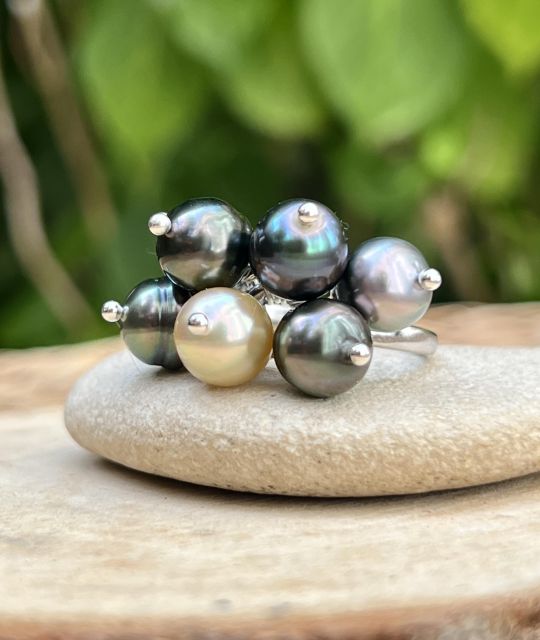 Bague en argent rhodié ornée de 7 perles de Tahiti cerclées. Un bijou élégant et contemporain qui met en valeur la beauté authentique des perles tahitiennes et leurs reflets naturels.