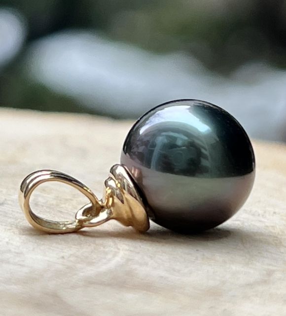 Sa teinte bleu violet révèle de profonds reflets changeants, tandis que la bélière godronnée apporte une touche d’orfèvrerie élégante et raffinée.