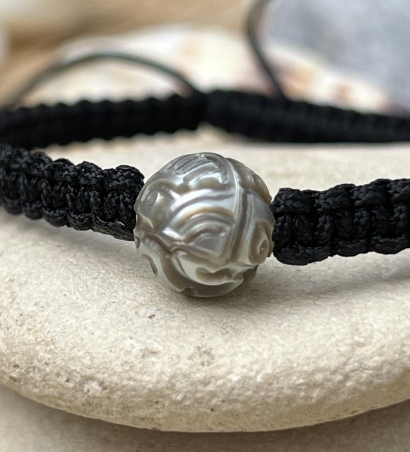 Découvrez la superbe perle gravée de couleur gris clair montée en bracelet tressé dans notre atelier à Nantes - certifié et garanti - livraison rapide
