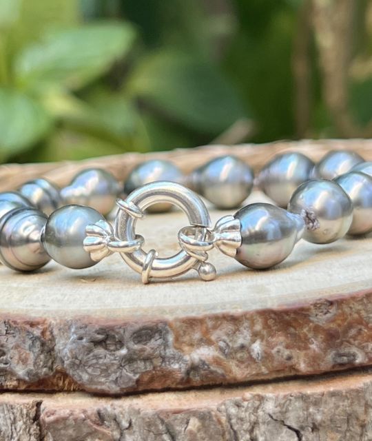 Intensiv irisierende Tahiti-Perlen folgen aufeinander in einem ständig wechselnden Glanz. Je nach Lichteinfall spiegeln sie Rosa-, Grün- oder Blautöne wider und offenbaren eine einzigartige Schwingung.