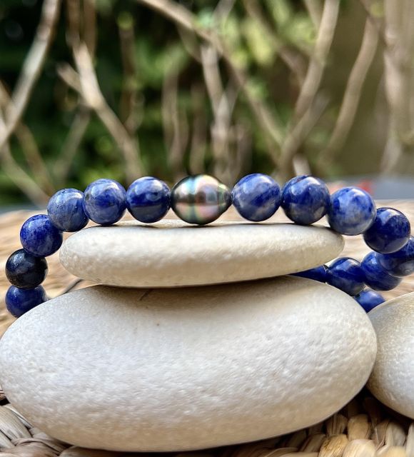 ポリネシアの記憶と鉱物の力が交差する場所で、ソーダライトが光を捉える動く輝きのあるピーコックブルーのタヒチパールと出会います。