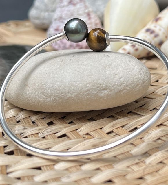 Découvrez sans attendre ce bracelet jonc perle de Tahiti en pièce unique - vertus de la perle et de l'oeil de tigre sont réunies pour votre bien-être