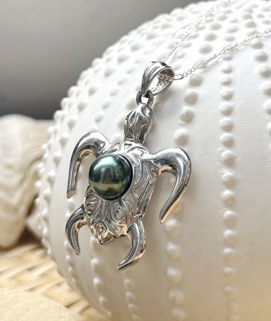 Une magnifique perle de Tahiti de couleur vert pistache au lustre éclatant accompagne ce pendentif homme tortue, symbole des lagons polynésiens - certificat GIA