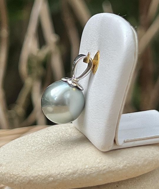 Ihre graue Farbe mit aquagrünen Reflexen wird durch einen strahlenden Glanz hervorgehoben, der eine kraftvolle und leuchtende Präsenz bietet.