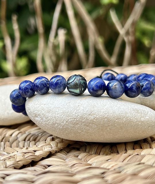 Herrenarmband aus natürlichen Sodalithen und einer runden Tahiti-Perle von 9,82 mm, grün gefärbt und mit marquesanischen Mustern graviert.