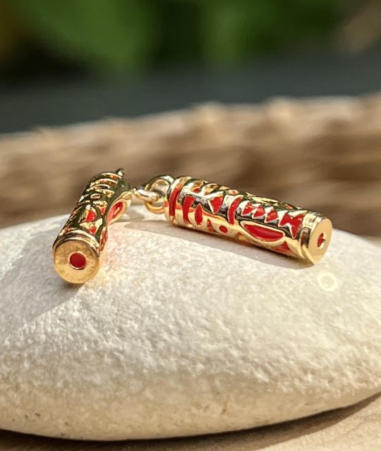 Boucles d’oreilles Tiki plaqué or et résine corail, symbole d’harmonie. Légères, lumineuses, inspiration polynésienne.