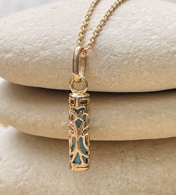 Pendentif en argent plaqué or et résine bleue en forme de Tiki Tahitien : incarnation de la puissance et de la tradition polynésiennes