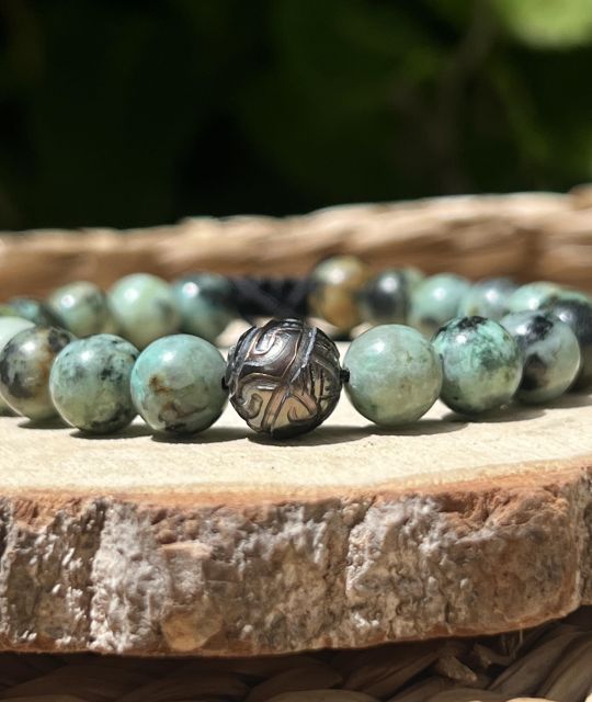 Découvrez ce bracelet en turquoises naturelles orné d’une Perle de Tahiti gravée de motifs marquisiens. Une création authentique inspirée de la Polynésie française