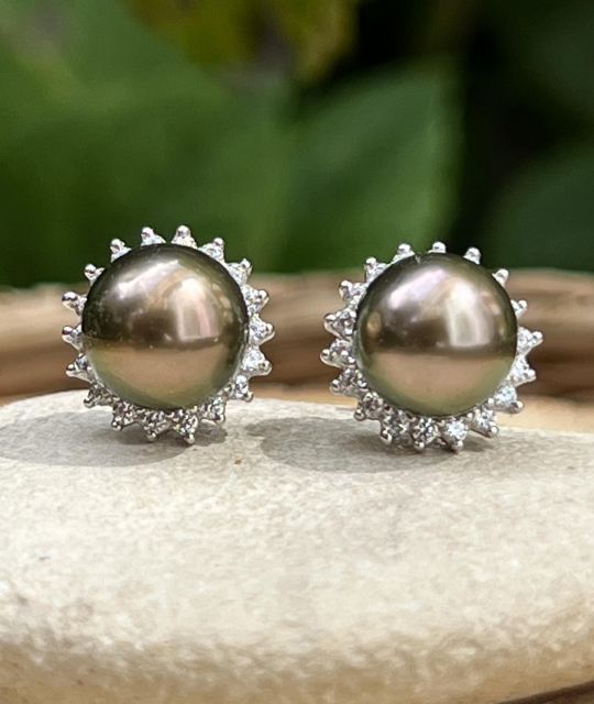 Deux perles nées du lagon, entourées d’un halo de lumière. Un reflet aubergine, un soupçon d’or rose, et la promesse d’un matin qui ne s’éteint pas.