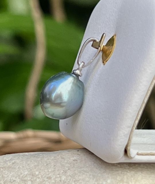 Une perle de Tahiti semi-baroque de 9,80 mm, peacock bleu lagon au lustre excellent, illumine l’argent rhodié