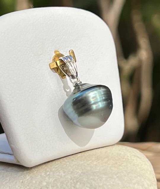 In rhodiniertem Silber bringt dieser Anhänger eine barocke Tahiti-Perle von 11,80 mm, umrandet, in Blau-Grau zur Geltung, mit glänzendem Schimmer – garantiert und zertifiziert.
