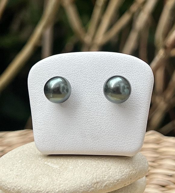 两颗塔希提珍珠，呈现稀有而明亮的青柠色光泽。它们卓越的光彩如同阳光洒在泻湖上般夺目。