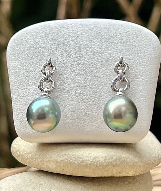 Die Ohrringe Lien Éternel rücken zwei Tahiti-Perlen in Tropfenform der Kategorie AAA von 9,34 mm ins Rampenlicht, mit der seltenen Farbe Pazifik-Sonnenuntergang.