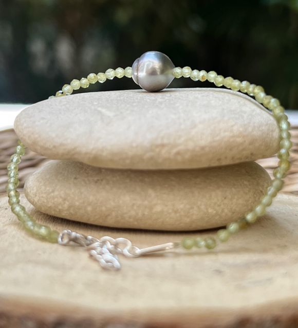 Découvrez le bracelet Te Hana en péridots naturels facettés et véritable perle de Tahiti semi-baroque cerclée de 9.02 mm. Une création lumineuse et élégante inspirée des lagons polynésiens.