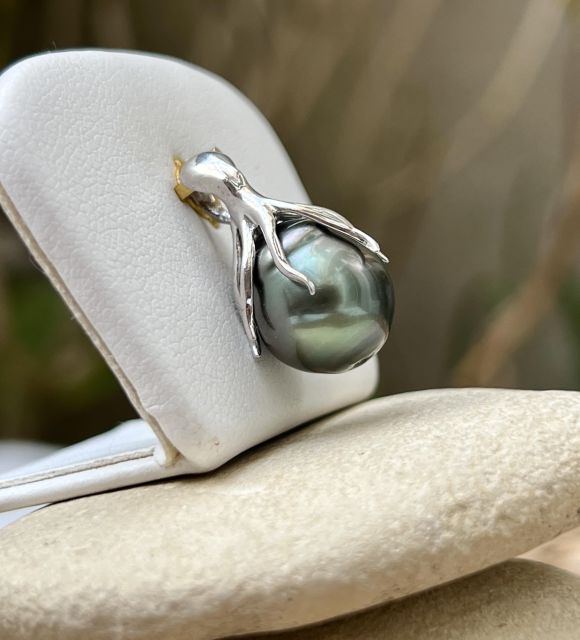 Ein rhodinierter Silberkrake umschließt eine halbbarocke, gerillte Tahiti-Perle mit einem Durchmesser von 11,55 mm, die grün ist und einen sehr schönen Glanz aufweist.