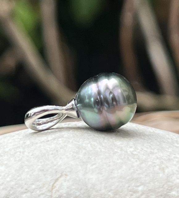 Une perle de Tahiti semi-baroque de 9,80 mm, peacock bleu lagon au lustre excellent, illumine l’argent rhodié