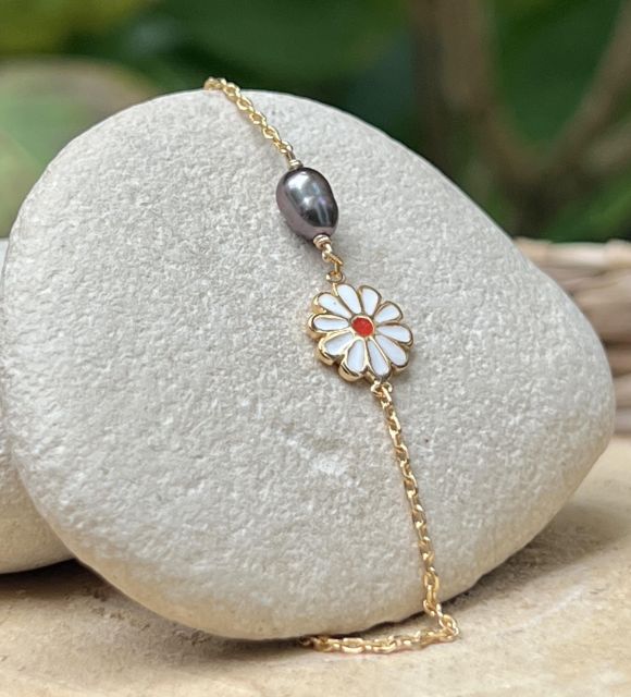 Hinara célèbre la douceur de l’enfance avec un keshi de Tahiti rose bleuté, comme une caresse de lagon, et une fleur au cœur joyeux.