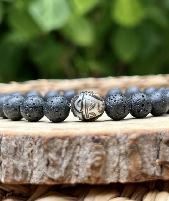 Découvrez notre bracelet en pierres de lave et perle gravée, une création au caractère minéral et élégant inspirée de la Polynésie française