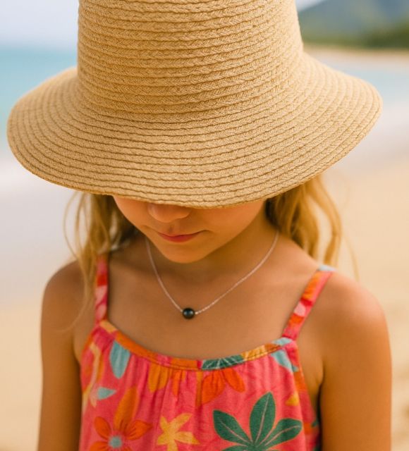 Une perle de Tahiti aux reflets doux glisse sur un fil d’or blanc. Un collier de perle discret et lumineux, pour accompagner les premières années avec grâce.