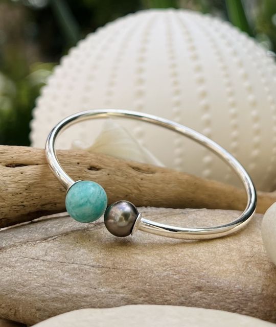 Entdecken Sie ein einzigartiges und zeitgenössisches Schmuckstück: das rhodinierte Silberarmband mit Larimar und einer authentischen Tahiti-Perle - GIA-Zertifikat.