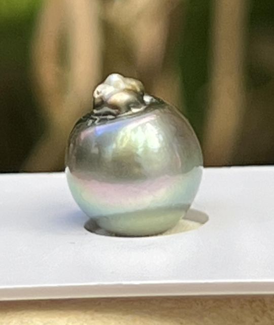 Une perle de culture de Tahiti baroque, au lustre brillant, dont la couleur gris irisé révèle de subtils reflets rose pâle et vert d’eau - livraison gratuite