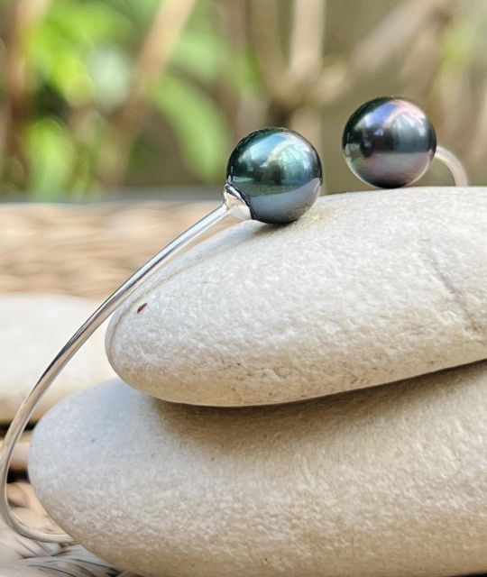 Zwei Tropfen Tahiti-Zuchtperlen, in Lagunenblau und Pfauenbronze, mit einer Größe von 9,36 mm und 9,47 mm, AAA-Qualität und mit ausgezeichnetem Glanz, ergänzen sich auf einem feinen und dezenten Reif.