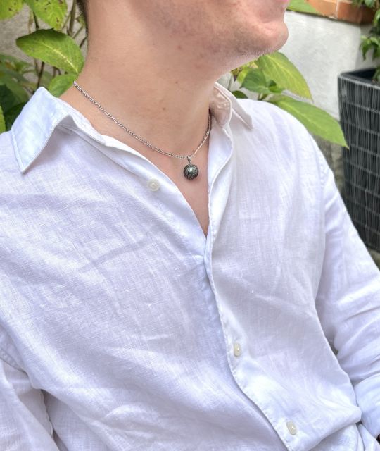 An einem Lichtfaden hängend, wird Mana Ora wie ein uralter Atemzug getragen — ein Talisman der Harmonie, geformt vom Ozean und der Erinnerung der Inseln.