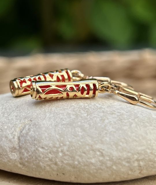 Boucles d’oreilles Tiki plaqué or et résine corail, symbole d’harmonie. Légères, lumineuses, inspiration polynésienne.