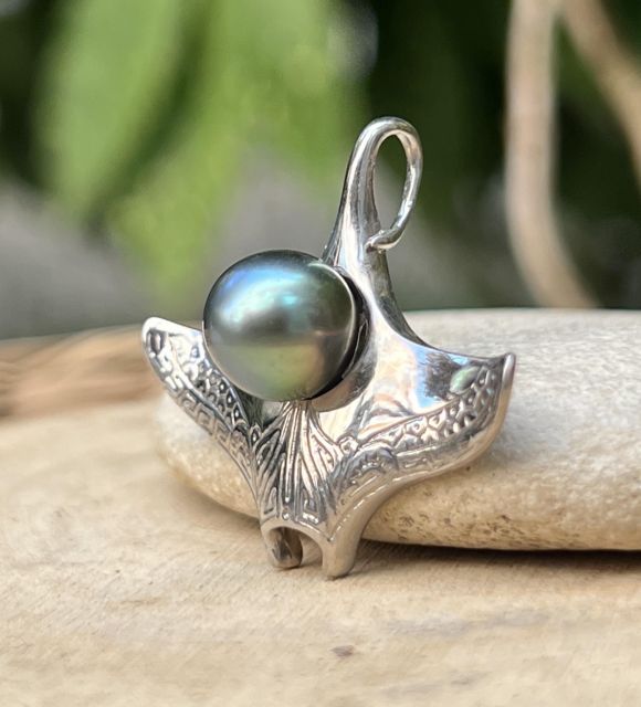 Inspiré par la grâce majestueuse des raies manta glissant au-dessus des récifs polynésiens, ce pendentif incarne la liberté, la fluidité et la lumière