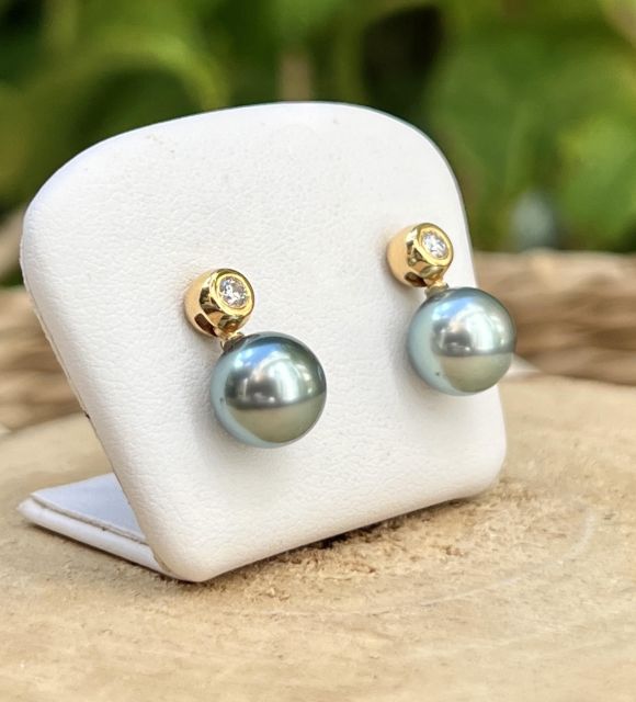 Un duo précieux : deux perles de Tahiti rondes, vert lagon, au lustre excellent, associées à deux diamants naturels sertis clos.