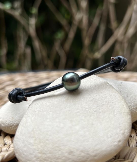 Schwarzes Lederarmband mit verstellbaren Knoten, verziert mit einer runden Tahiti-Zuchtperle (8,88 mm, Qualität A+) in der Farbe Pfau mit sehr hohem Glanz.