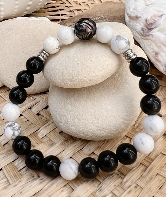 Entscheiden Sie sich für die Kombination aus Obsidian und Howlith in diesem Armband mit einer wunderschönen gravierten Tahiti-Perle in Auberginenfarbe - Zertifikat