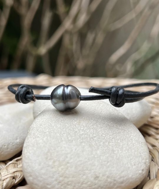 Schwarzes Lederarmband mit verstellbaren Knoten, verziert mit einer halbbirnenförmigen Tahiti-Zuchtperle (10,75 mm) in einem blau-grauen Auswahlton mit hervorragendem Glanz.