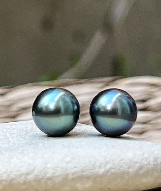 Les clous d’oreilles “Éclatante” mettent en lumière deux perles de Tahiti rondes de 9,00 mm, d’un vert profond et reflets bleus au lustre excellent et qualité AAA+