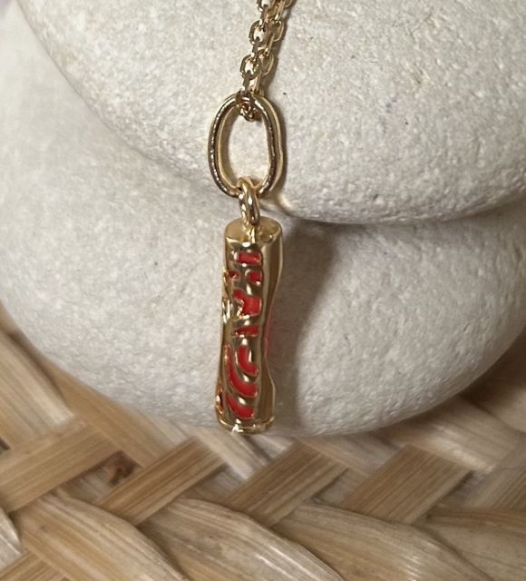 Pendentif en plaqué or et résine corail en forme de Tiki Tahitien : incarnation de la puissance et de la tradition polynésiennes