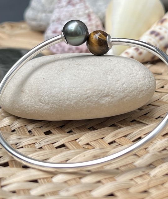 Entdecken Sie ohne zu zögern diesen einzigartigen Tahiti-Perlen-Armreif - die Tugenden der Perle und des Tigerauges vereinen sich zu Ihrem Wohlbefinden.