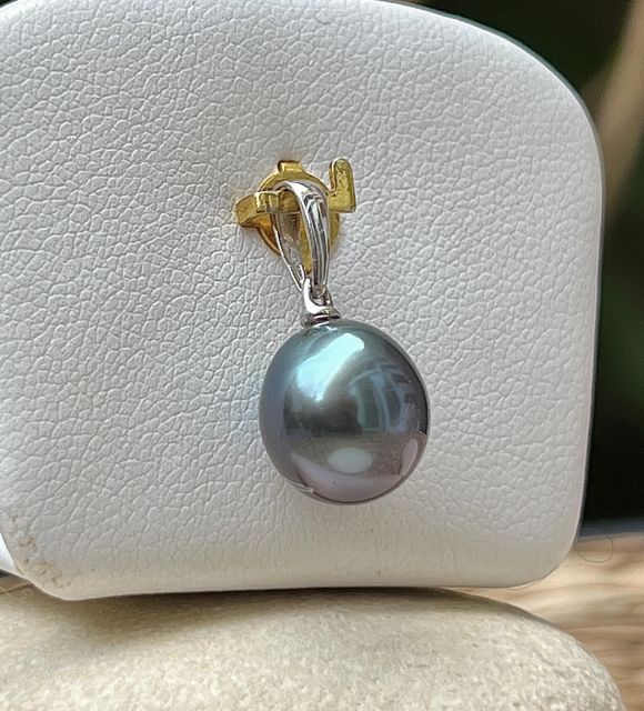 Pendentif en or blanc 18 carats orné d’une perle de culture de Tahiti drop de 9,54 mm, qualité AAA. Teinte bleu violet avec pointe peacock, lustre excellent
