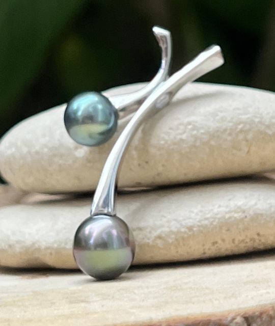 Pendentif en argent rhodié orné de deux perles de Tahiti AAA aux couleurs bleu lagon et bleu violine. Lustres excellents et élégance inspirée du Pacifique.