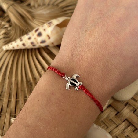 赤いコットンブレスレットと銀のカメと黒のエナメル