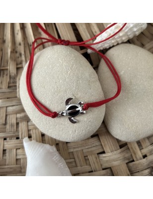 赤いコットンブレスレットと銀のカメと黒のエナメル